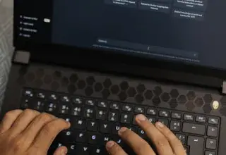 Mains tapant sur un ordinateur portable affichant l interface ChatGPT, illustrant la technologie IA