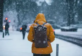 Personne portant un anorak et un sac à dos dans le froid hivernal