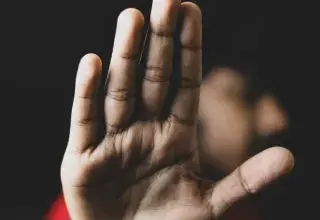 Main gauche sur fond noir, symbolisant la menace et la violence