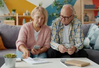 Couple examinant des documents financiers pour gérer le budget familial