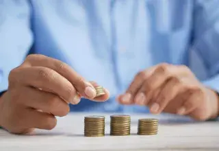 Une personne empilant des pièces de monnaie sur une table