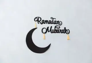 Décoration minimaliste Ramadan Mubarak avec un croissant de lune sur un mur clair