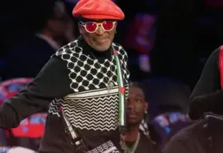 Spike Lee portant un pull keffieh et un sac aux couleurs du drapeau palestinien lors du NBA All-Star Game à Los Angeles