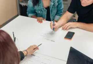 Un couple discute de documents d'adoption avec un professionnel dans un bureau