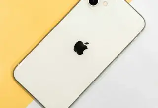 iPhone argenté posé sur une table blanche