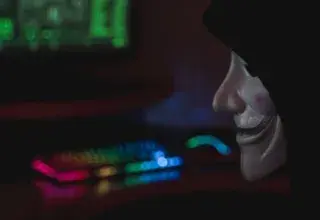 Silhouette mystérieuse devant un écran d'ordinateur symbolisant les menaces de cybersécurité