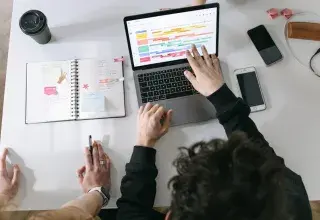 Deux personnes collaborant devant un ordinateur portable dans un bureau moderne