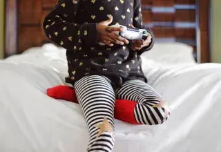 Enfant jouant aux jeux vidéo sur une manette de console