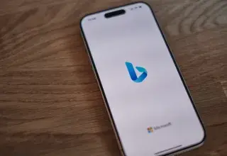 Un téléphone portable posé sur une table en bois affichant le moteur de recherche Bing