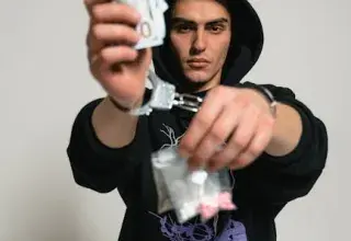 Une silhouette encapuchonnée tient des billets et des menottes, symbolisant le crime et l'enquête policière