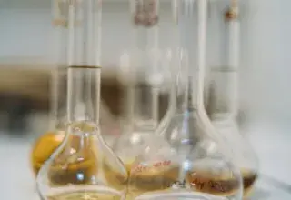 Close-up of various vials with liquids on a lab table.
