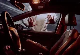man in white long sleeve shirt driving car