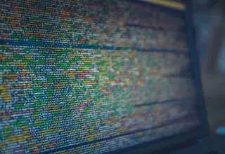 Vue rapprochee d'un code source colore affiche sur un ecran d'ordinateur, illustrant la cybersecurite et la protection des donnees.