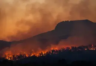 wildfire burning across hillside at dusk