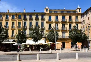 Sunny day in Aix-en-Provence with classic French architecture and bustling street life.