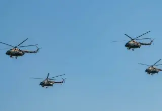 Four military helicopters flying in formation against a clear blue sky in Belgrade, Serbia.
