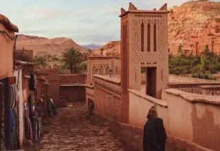 people walking on pathway near brown concrete building during daytime