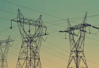 black transmission towers under green sky