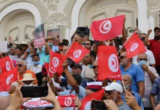 a large group of people holding flags in front of a building