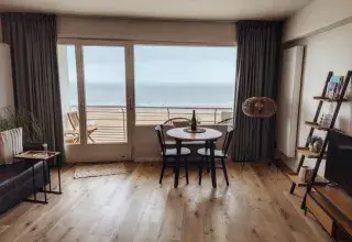 Salon lumineux d'un appartement en bord de mer avec vue sur l'océan. Photo : Russell Butcher / Pexels