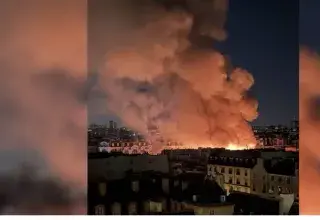 Incendie du marché des Enfants-Rouges à Paris, panache de fumée au-dessus des toits du Marais dans la nuit