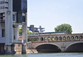 Le bâtiment Colbert du ministère de l'Économie et des Finances à Bercy, au bord de la Seine, avec le pont de Bercy et une rame de métro
