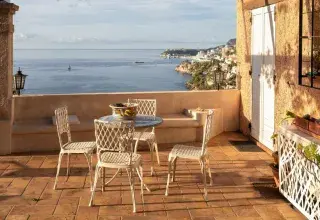 Terrasse en terre cuite avec table et chaises donnant sur la mer Méditerranée