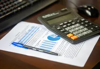 Calculatrice, stylo et document financier avec graphiques sur un bureau