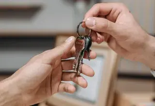 Deux mains échangent un trousseau de clés dans un intérieur