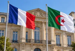 Illustration générée : drapeaux français et algérien devant la façade d'une préfecture.