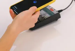 Personne payant avec un smartphone sur un terminal de paiement sans contact