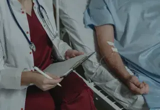 Médecin examinant un dossier médical auprès d'un patient