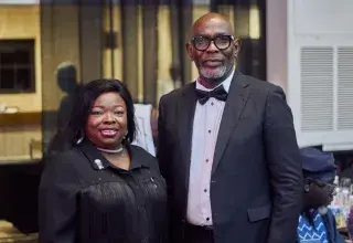 Deux invités en tenue de soirée souriants lors d'un événement de gala