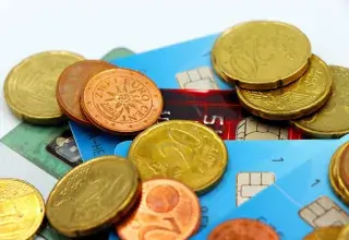 Pièces de monnaie en euros posées sur des cartes bancaires