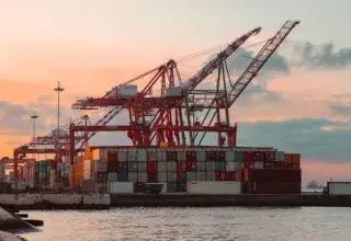 Grues de port et conteneurs au coucher du soleil
